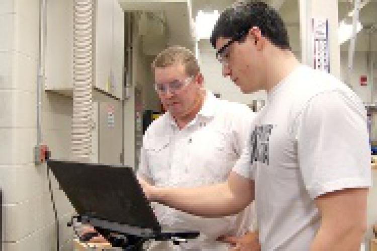 Students working on the computer controlling the CNC router